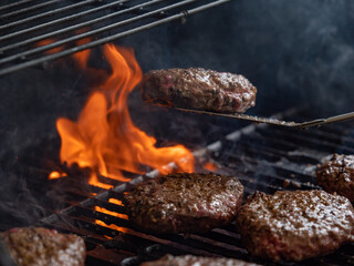 burgers cooking on an open flame grill top