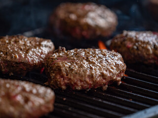 burgers cooking on an open flame grill top