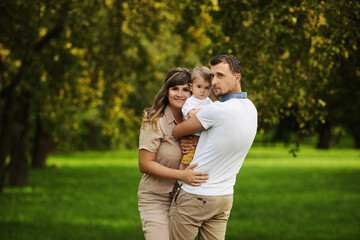 Fototapeta premium Happy family: mother, father and son on nature in summer day.