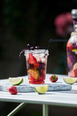 Delicious refreshing lemonade with basil, lime and strawberries. Summer drink with ice. Home made production.