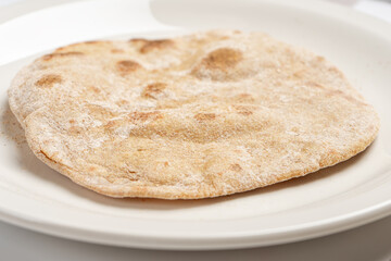 Flatbread on a white plate close-up