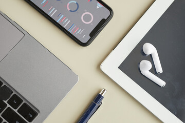 Top view close up of modern business devices laptop, tablet and smartphone over minimal background, copy space