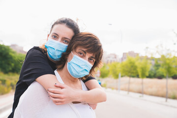 New normal. Family members hugging. Mother and daughter hugging protected against the coronavirus. Safety and pandemic concept. Coronavirus. Social distance. Family protected with masks.