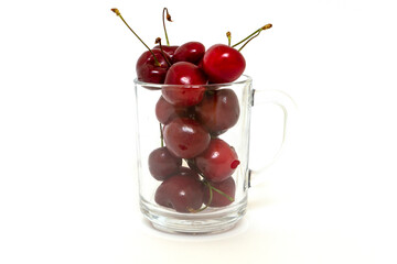 Fototapeta na wymiar transparent cup full of red ripe cherries isolated