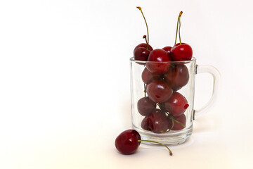 transparent cup full of red ripe cherries isolated