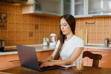 A young girl works at home on a remote site. Distance learning. Stay at home