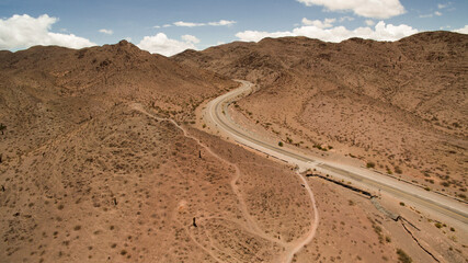 Fototapeta na wymiar Travel. Aerial view of the desert asphalt route crossing the arid mountains in Los Cardones National Park. 