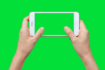 Woman hand shows mobile smartphone with green screen in horizontal position isolated on green...