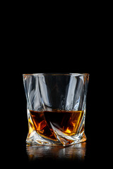 Glass of whiskey on black background