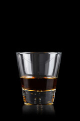 Glass of whiskey on black background