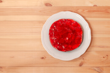 Strawberry cake on white plate on wooden table