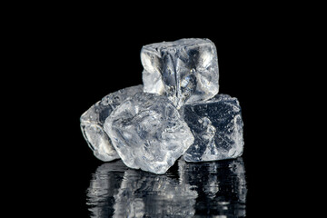 Ice cubes reflection on black table background