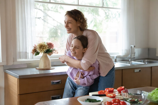 Happy Young Caucasian Mom And Teen Daughter Have Fun Laugh Cooking Together At Home Kitchen, Overjoyed Mother And Teenage Daughter Feel Crazy Playful Preparing Food Together, Family Concept