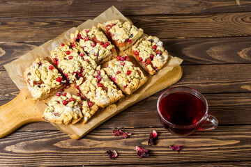 sliced ​​homemade grated pie with berries on a wooden board.