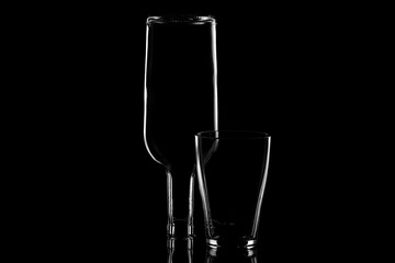 the glass and the inverted bottle are backlit by the light along the contour