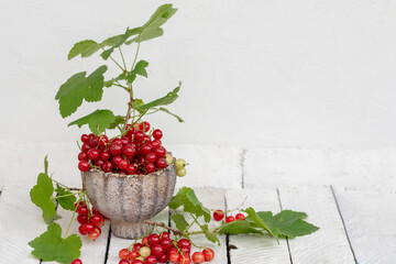Ripe red currants with leaves, wooden table