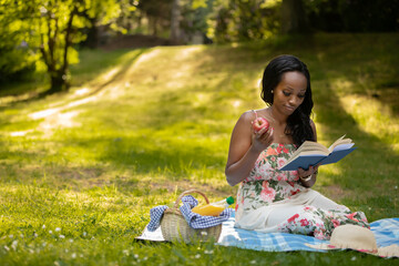 Attractive woman is reading a book at picnic