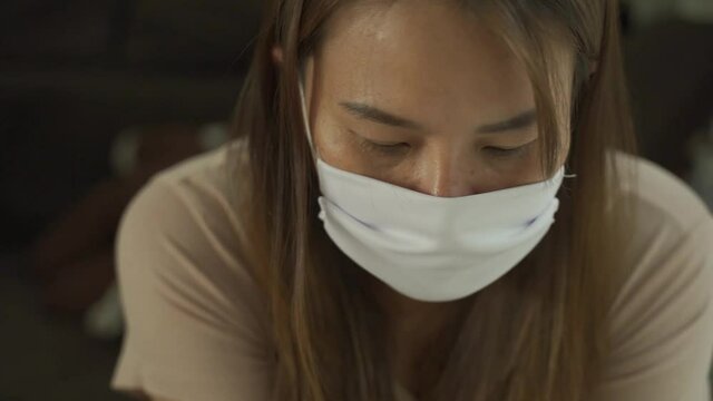A woman wearing a protective mask in a healthcare setting during an epidemic