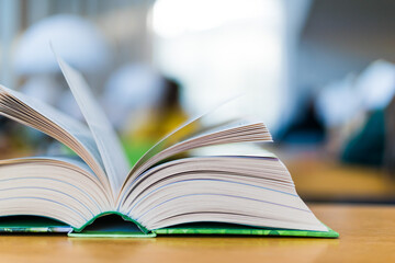 Open book lying on the table in the library