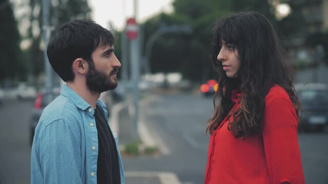 Young Couple Giving A Knowing Look And Staring Worriedly At The Camera