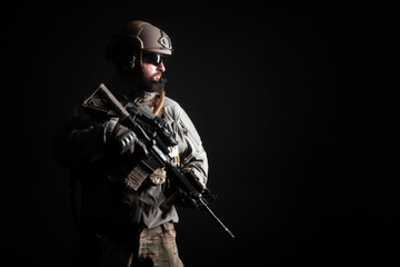portrait of a special forces soldier in uniform with a weapon against a dark background, elite...