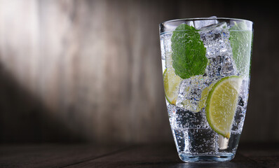 Glass of mineral water with ice, lime and mint