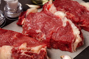 three steaks of raw marbled beef on the table, close-up