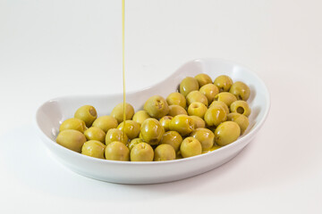 plate of olives on which a jet of oil falls
