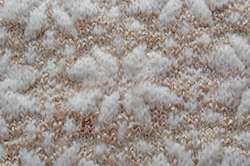 the texture of the knitted pattern in pastel shades of white and brown