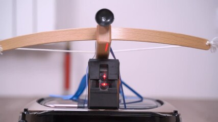 Crossbow, arrow with suction cup and infrared sight on stand as catapult prepared for battle, close up. Toys for playing war at home. Entertainment and leisure with children on holidays - Powered by Adobe