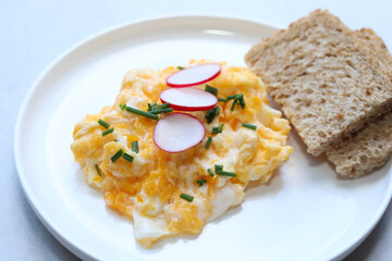 Scrambled eggs on a white plate. Healthy food or breakfast concept.