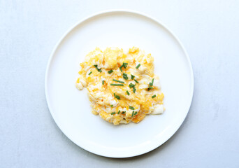 Fototapeta premium Scrambled eggs on a white plate. Healthy food or breakfast concept.