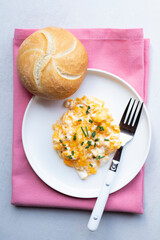Scrambled eggs on a white plate. Healthy food or breakfast concept.