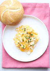 Scrambled eggs on a white plate. Healthy food or breakfast concept.