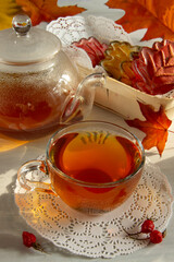 A Cup of tea and cookies in the form of leaves.