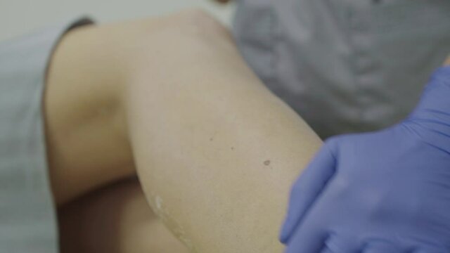 Close view of rubbing talc on the leg during depilation treatment
