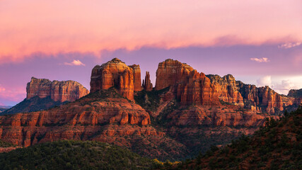 Cathedral Rock in Sedona, Arizona during a beautiful sunset with pink skies and clouds. 