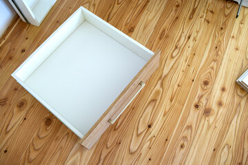 Close up of installation of wooden drawer in contemporary cupboard cabinet.