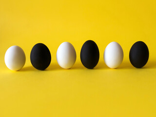 Black and white eggs on the yellow background. Black lives matter, all lives matter, diversity,  equal rights concept