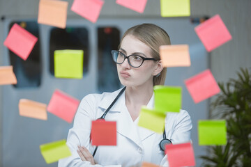 An emotional young doctor in the office, with a stethoscope around his neck and in a white coat,...