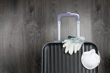 Medical mask, gloves and sanitizer on a luggage