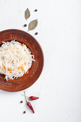 Sauerkraut with ingredients on a white table
