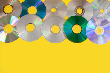 Kolorowe płyty cd na żółtym tle