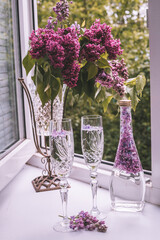 glass of water with flowers lilac in a glass
