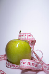 Red measuring tape over green apple. Diet and Healthy life, loss weight concept. Top view. Copy space. Isolated. White background. High quality photo
