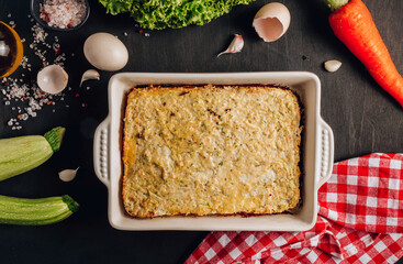 Zucchini casserole on dark background. Dietary, low-calorie, healthy food. Homemade Casserole from squash with chicken and eggs.