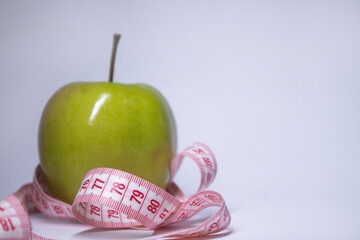 Red measuring tape over green apple. Diet and Healthy life, loss weight concept. Top view. Copy space. Isolated. White background. High quality photo