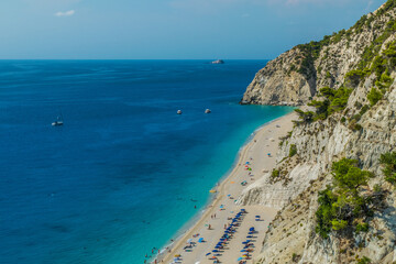 Fototapeta na wymiar Photo of Egremni beach with turquoise water and full of people sunbathing at Lefkada island, Greece