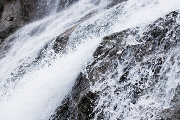 Close up of a mountain waterfall and water bumping into the rocks.