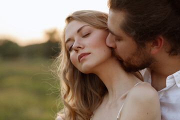 The guy kisses the girl in the neck. close-up portrait